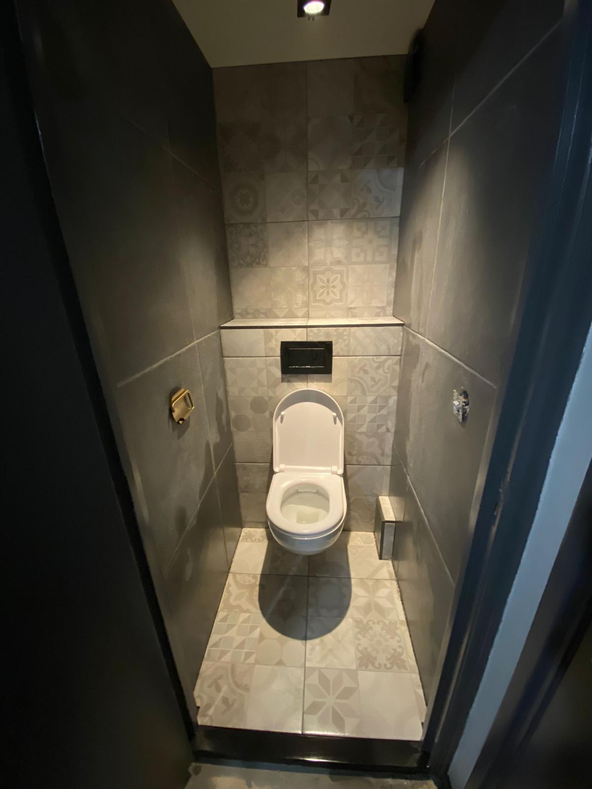 Toilet ná de renovatie, met hangtoilet en patroontegels